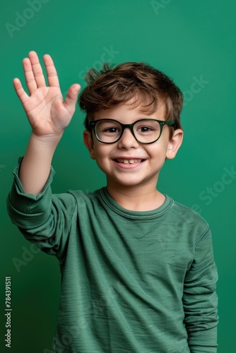 A young boy wearing glasses waving his hand. Suitable for educational and back to school concepts
