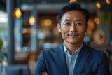 A confident Asian man smiling in a well-lit restaurant, projecting an aura of success and happiness