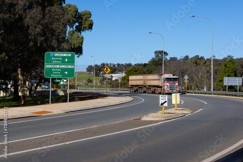 road signs on the Albany Highway through Williams with road train carting grain photo