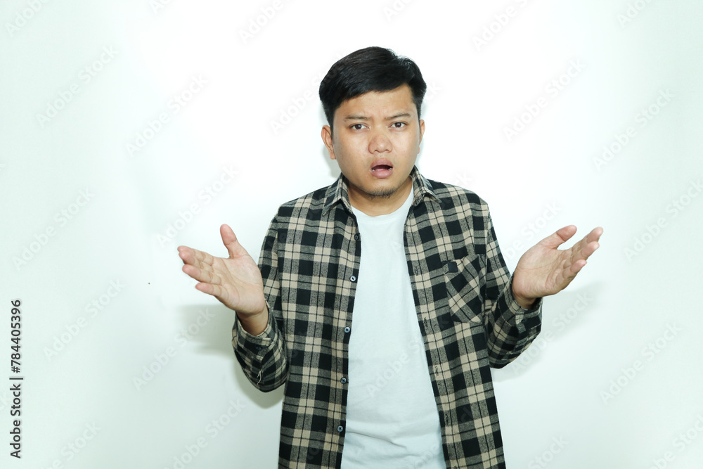 Young Asian man looks at the camera with a confused expression Young Asian man looks at the camera with a confused expression