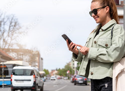 Mobility as a service. Urban woman searches rental car, rental transport using her smart phone. photo