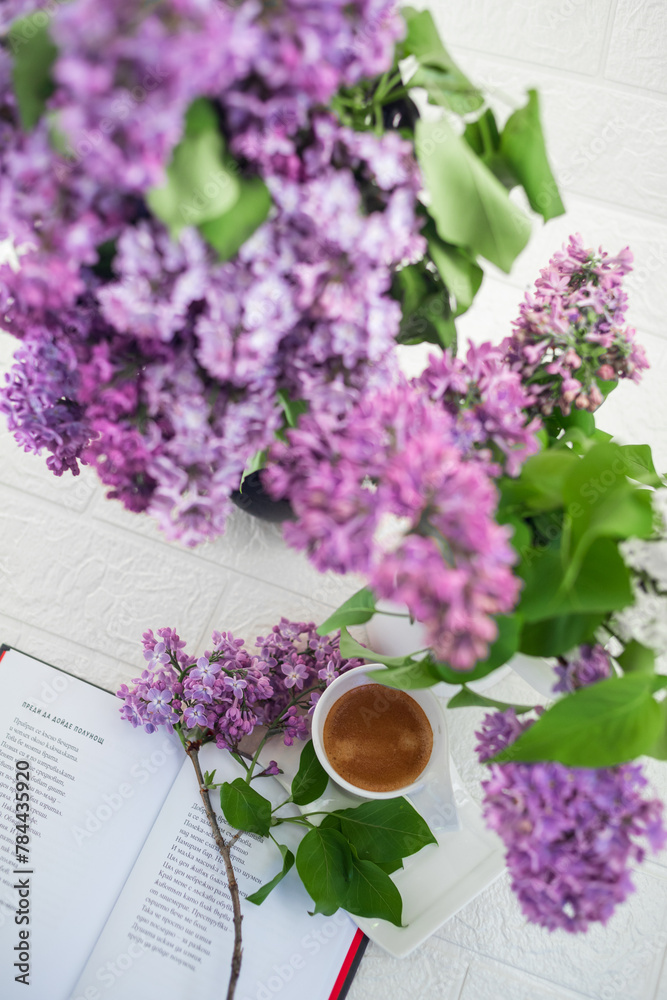 A bouquet of flowers on the window and coffee in a white cup in the rays of sunlight. A bouquet of lilacs and a cup of coffee.
A bouquet of flowers on the window and coffee in a white cup in the rays of sunlight. A bouquet of lilacs and a cup of coffee.