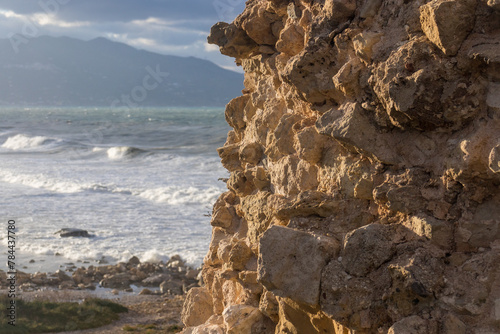 Windy day at the beach. Big waves. view from a rocky spot above tha beach. Mountains in the backround. 