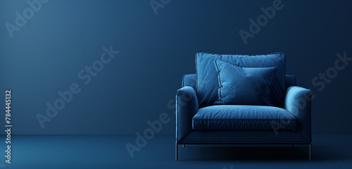 Sleek blue armchair with soft texture against a dark blue backdrop. photo