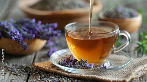 Cup of healthy lavender tea and dry lavender flowers. Bowls of dry medicinal herbs on background © May