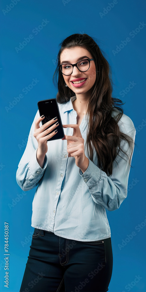 Girl holding a smartphone in her hands on a blue background
Girl holding a smartphone in her hands on a blue background