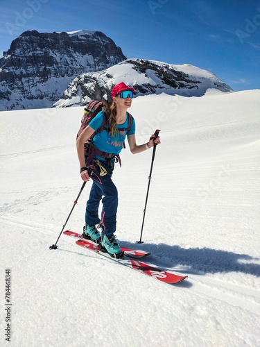 young woman ski touring over the glacier in the Glarus and Uri Alps. Ski tour enjoying the freedom in the Swiss mountains. Ski mountaineering on the Gemsfairen Gemsfairenstock and over the Clariden gl photo