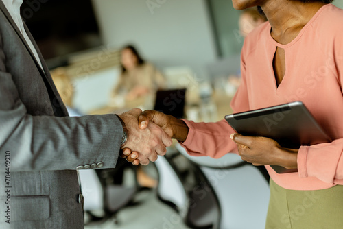 Professional handshake between colleagues in a modern office setting during daylight hours