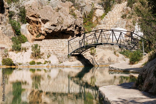 Puente de hierro de forja en piscina natural del municipio de Bolbaite con reflejos en el agua, España photo