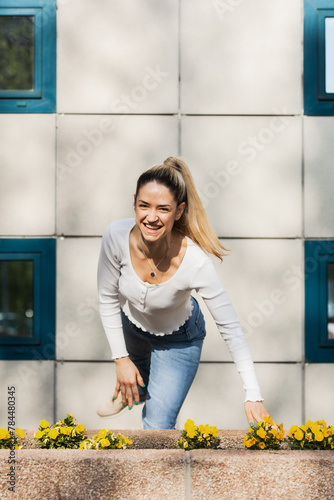 Beautiful girl jumping infront of modern building facade.