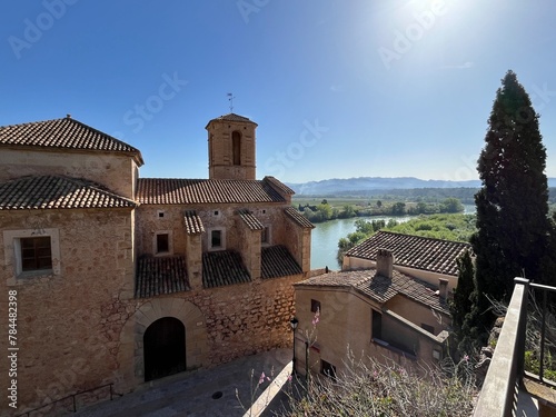 Church within Spanish village of Miravet at the river Ebro on sunny day with bright Blue sky