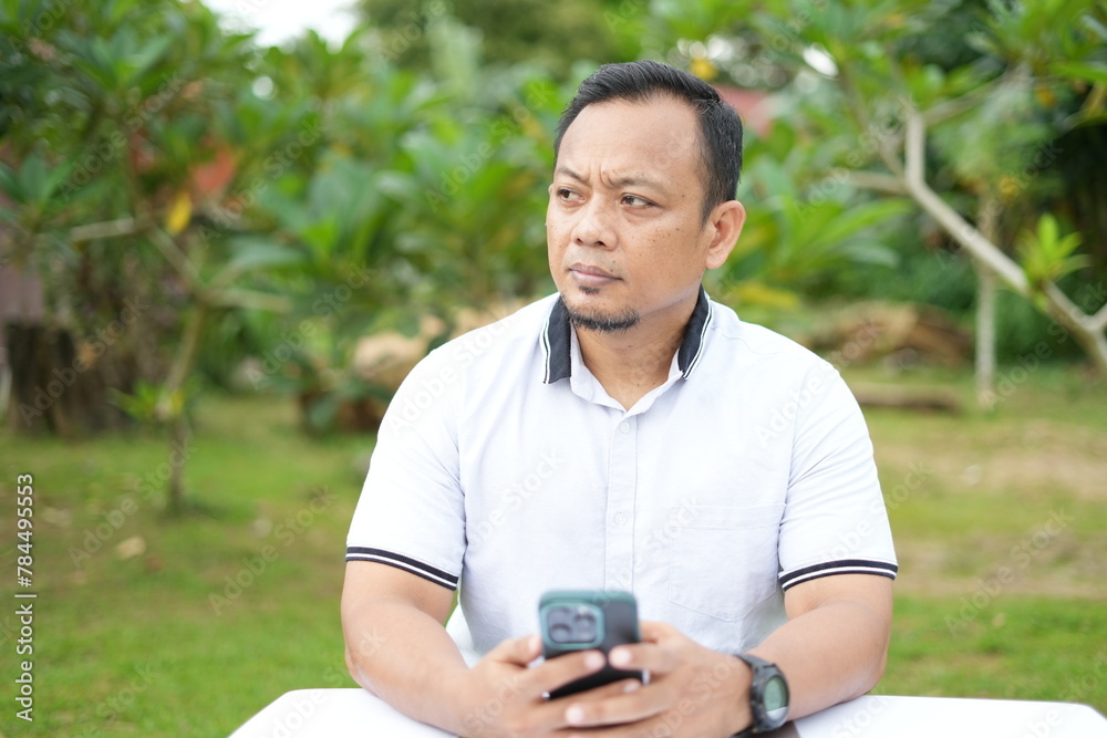 The facial expression of a sitting Asian man The facial expression of a sitting Asian man