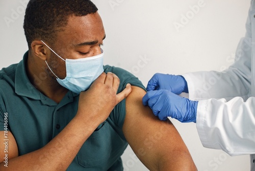 Black guy isolated on white background is going to have covid vaccination