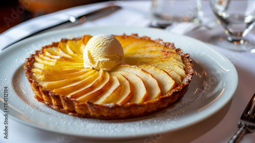 Delicious argentine apple tart topped with a scoop of vanilla ice cream, served on a white plate