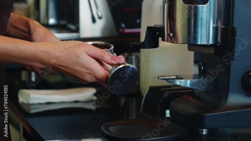 Fresh tasty coffee brewed by coffee machine in cafe or pub. Step by step guide to professional coffee making. Close up of machine hand holding handle pouring espresso. photo