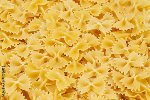 Dry uncooked farfalle pasta as a background. Flat lay.