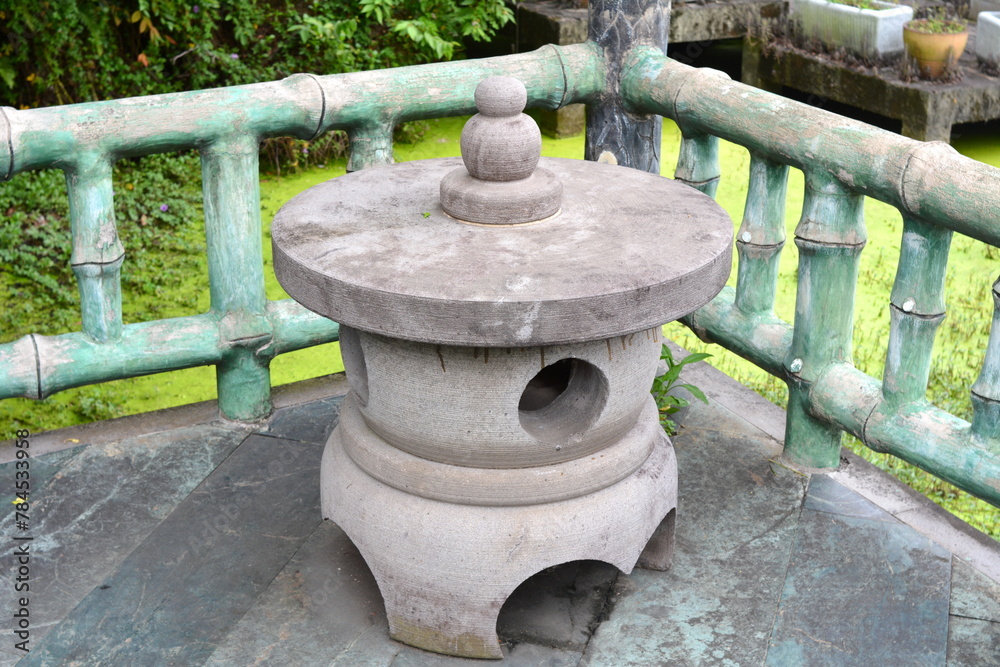 Ancient stone table by the pond