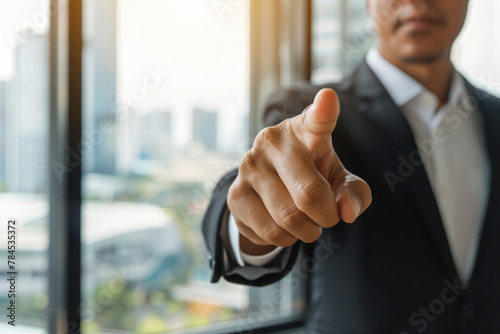 A man in a suit is pointing at something with his finger