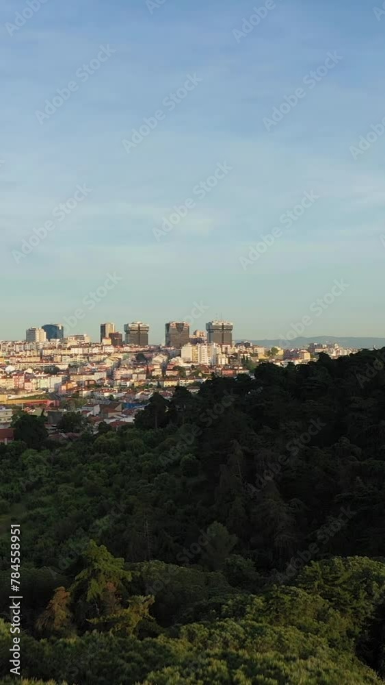 Lisbon Skyline and Monsanto Forest Park. Golden Hour. Portugal. Aerial View. Drone Moves Forward and Upwards. Reveal Shot. Vertical Video Lisbon Skyline and Monsanto Forest Park. Golden Hour. Portugal. Aerial View. Drone Moves Forward and Upwards. Reveal Shot. Vertical Video