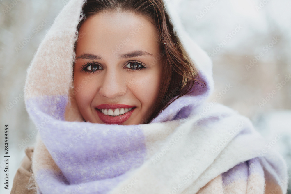 Obraz premium Young woman face covered with light colored knitted scarf