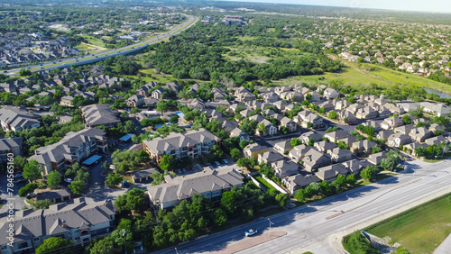 Urban sprawl mixed of apartment complex and single family houses subdivision in lush greenery area along busy E Whitestone Blvd and Brushy Creek Road in Cedar Park, Austin, Texas, aerial view photo