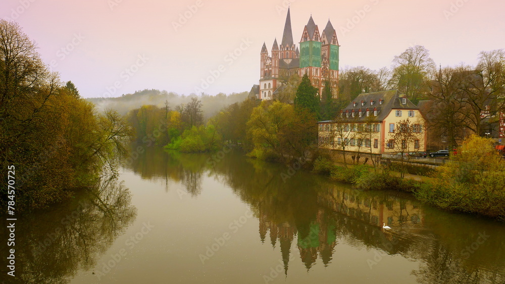 mächtiger Limburger Dom spiegelt sich im Morgenrot   im Fluss Lahn