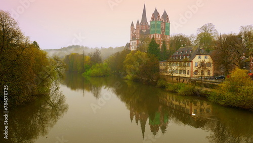 mächtiger Limburger Dom spiegelt sich im Morgenrot im Fluss Lahn