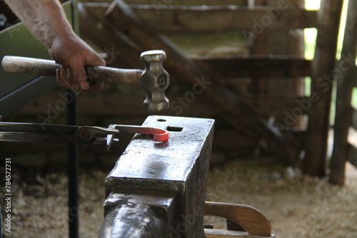 A Blacksmith Hammering Red Hot Metal on an Anvil.