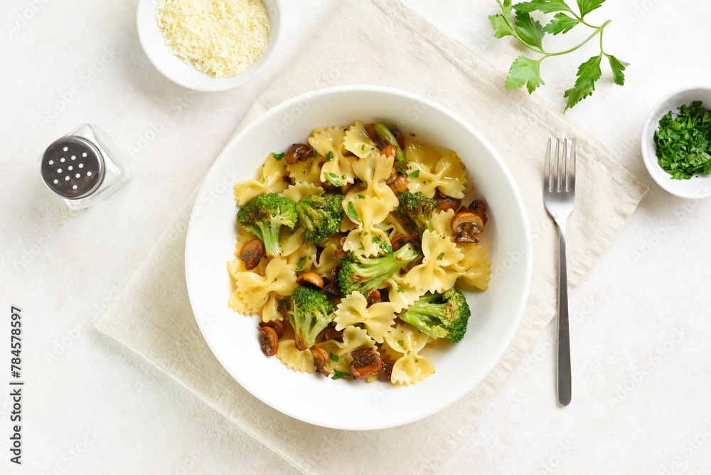 Farfalle pasta with roasted broccoli and mushrooms in bowl - obrazy, fototapety, plakaty 
