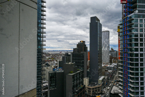 The intricate detail of Brooklyn s urban fabric is captured from a high vantage point  with the Hudson River flowing in the distance  framing the multifaceted city life below.