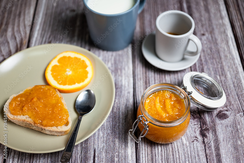 Healthy breakfast with homemade orange marmalade. Breakfast with slice of bread with jam, coffee and a cup of milk Healthy breakfast with homemade orange marmalade. Breakfast with slice of bread with jam, coffee and a cup of milk