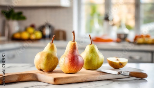 A selection of fresh fruit: pears, sitting on a chopping board against blurred kitchen background; copy space 