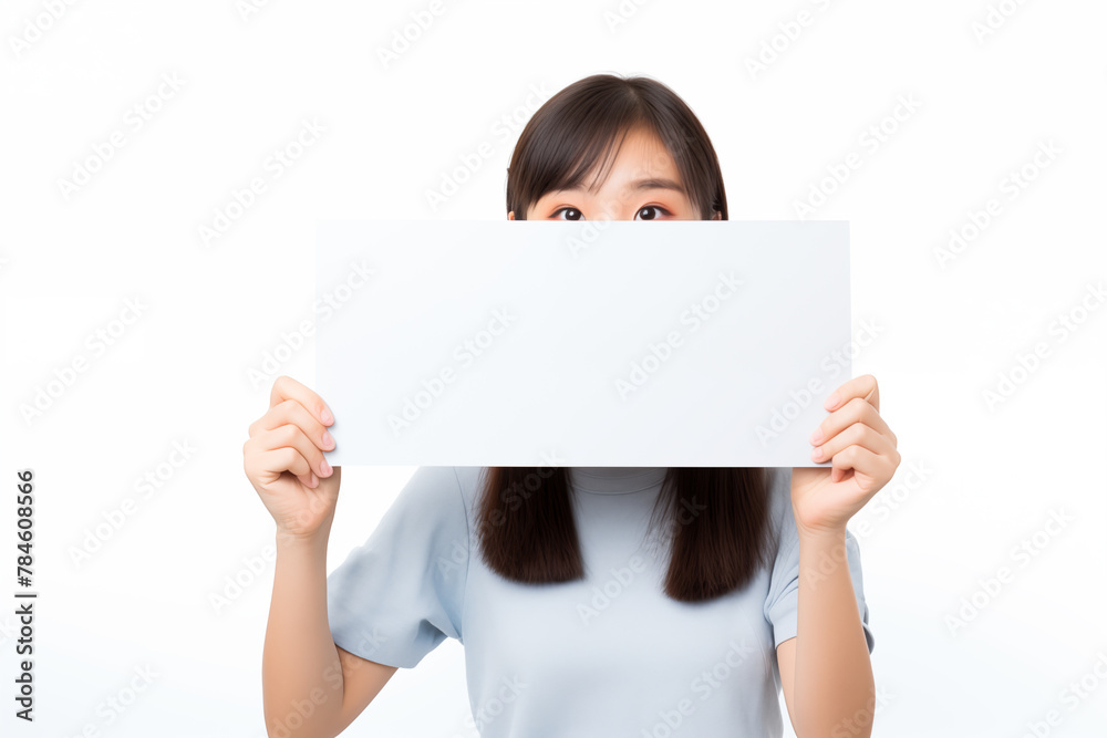 Teen pretty Japanese girl over isolated white background holding an empty placard Teen pretty Japanese girl over isolated white background holding an empty placard