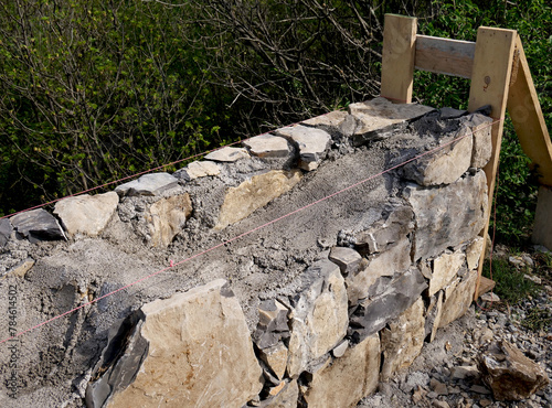 Renovation of a low wall with stone and concrete