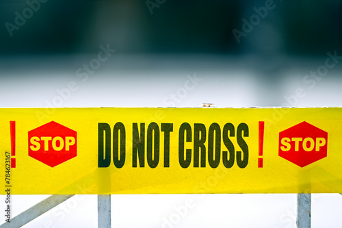 Stop. Do Not cross! Warning yellow tape on fence at crime place