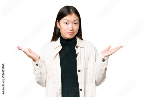 Young Asian woman over isolated chroma key background making doubts gesture