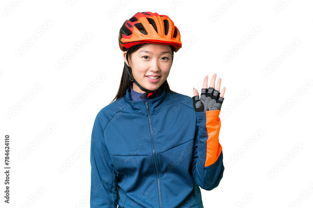 Young cyclist woman over isolated chroma key background saluting with hand with happy expression