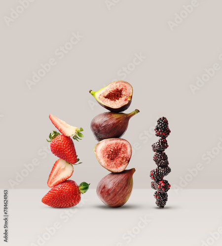 Creative layout made of strawberry, figs and blackberry on the beige background. Food concept. Macro concept. (ID: 784624963)