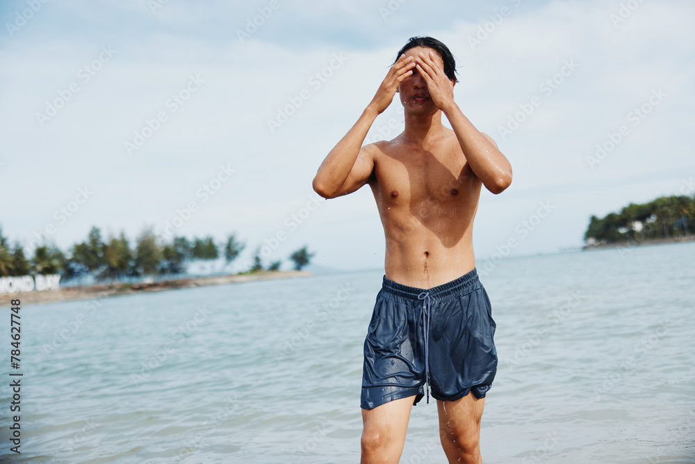 Swim Vacation: Asian Man Enjoying Tropical Water Fun with Friends at the Beach