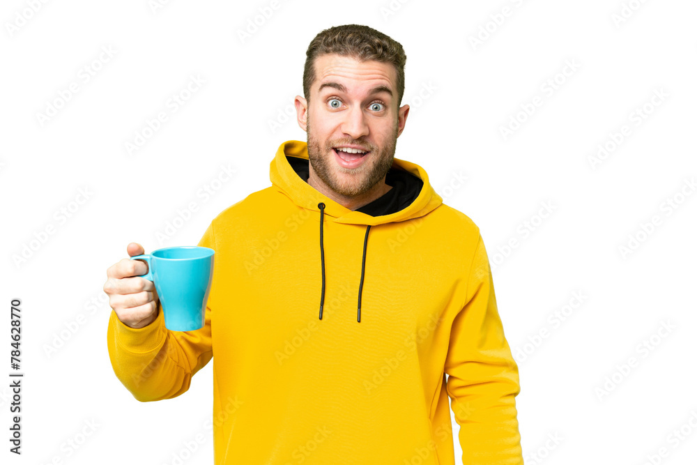 Obraz na plátně Young handsome blonde man holding cup of coffee over isolated background with su
