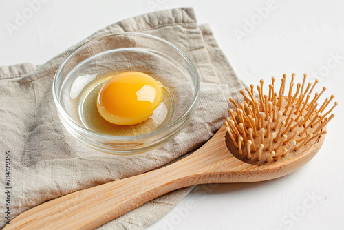 Raw Egg in a Bowl and Wooden Hairbrush