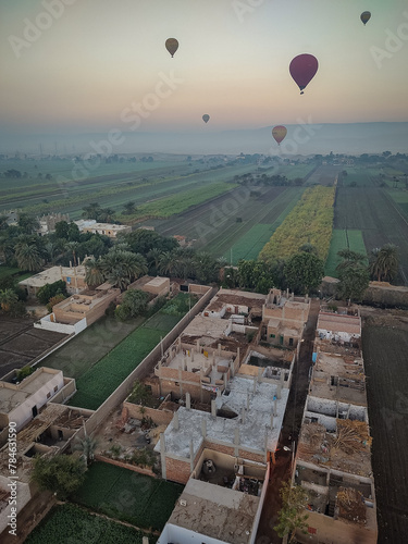 view  from a hot air balloon of the fertile Nile Valley and homes on the West Bank as the sun rises
