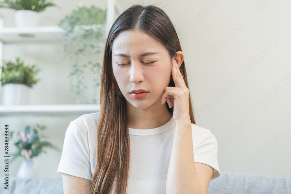 Tinnitus concept, sick asian young woman, girl have ear pain or earache, hand touch plug ear, suffering painful otitis from loud of noisy sound, inflammation. Health care nerve deaf eardrum disease. Tinnitus concept, sick asian young woman, girl have ear pain or earache, hand touch plug ear, suffering painful otitis from loud of noisy sound, inflammation. Health care nerve deaf eardrum disease.