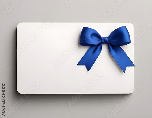 Blank white gift card with blue ribbon bow isolated on background with shadow minimal conceptual