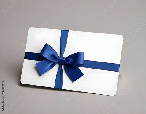 Blank white gift card with blue ribbon bow isolated on background with shadow minimal conceptual