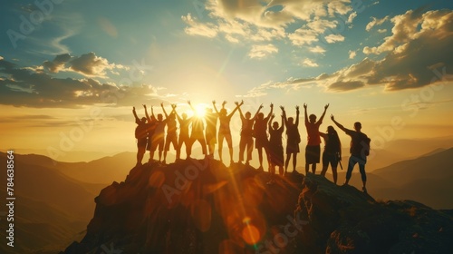 The silhouette of a large group against the setting sun on a mountaintop, their success pose reflecting a shared journey of endurance and triumph.