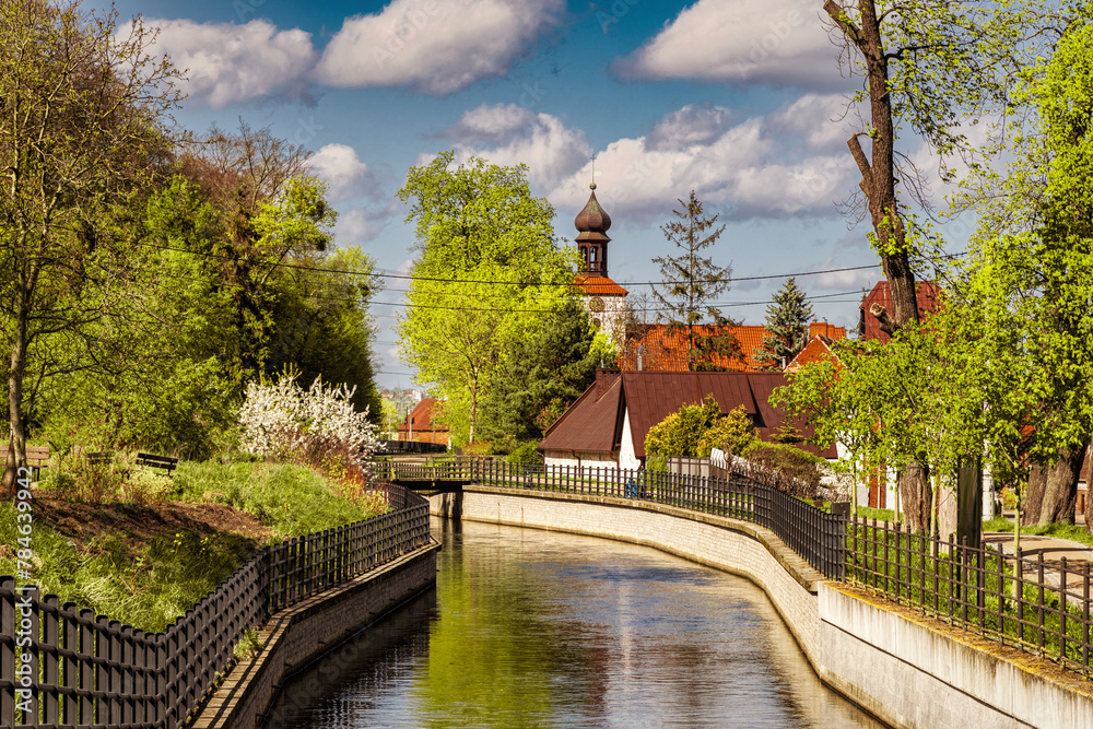 Fototapeta premium Beautiful spring countryside in Europe. Ancient church on the canal