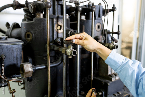 Obraz na płótnie A woman operates a complex mechanism. A girl working in a factory. w salonie