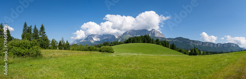 Grüne Almen und Wiesen in der Nähe des Wilden Kaiser Hochgebirges im Frühsommer, Panorama-Aufnahme.