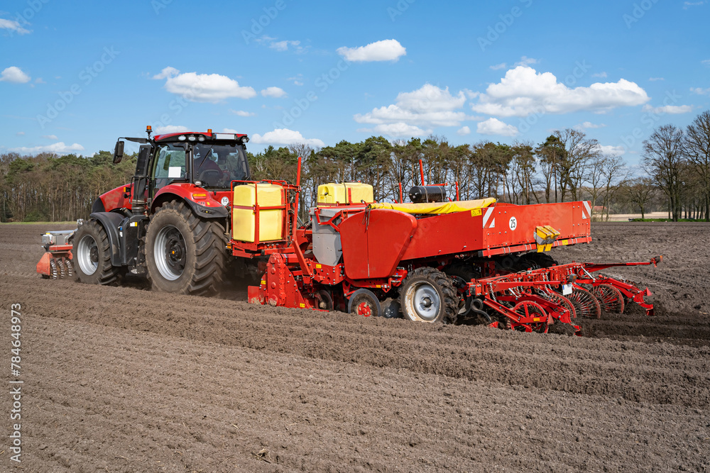 Obraz premium Kartoffeln legen mit moderner Landtechnik im Frühling - Heckansicht.
